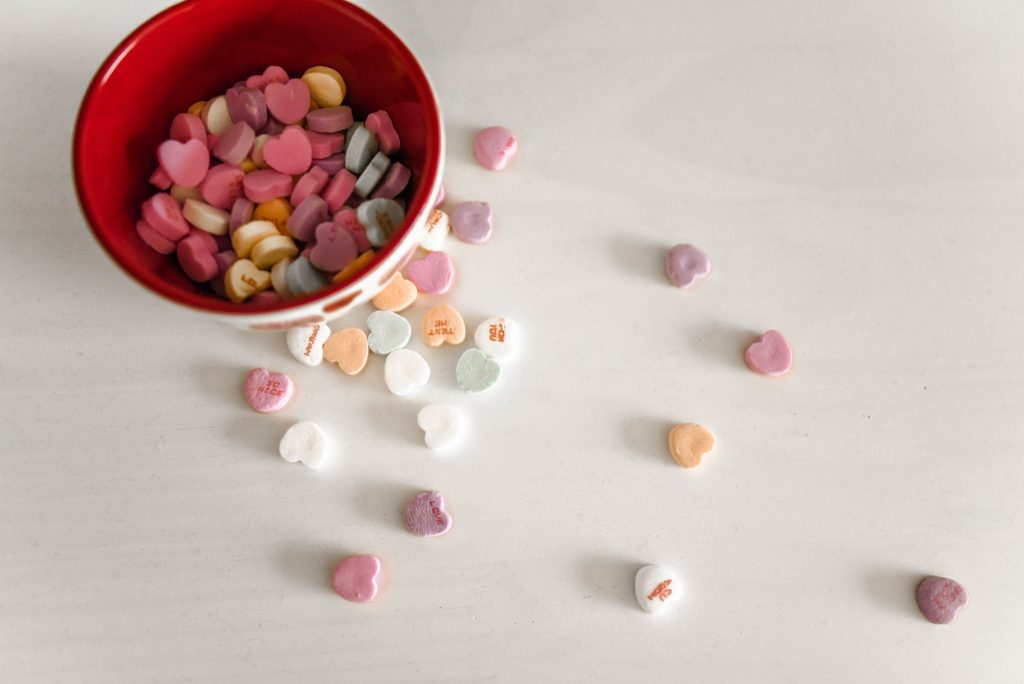 Low Waste, Zero Waste Valentine's Day World Threads Traveler, Cait Bagby, Red and Pink Bowls of Valentine's Day Conversation Heart Candies on a White Table