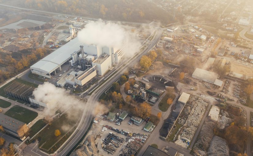 View from above of some kind of industrial plant pumping a white smoke or particulate into the air