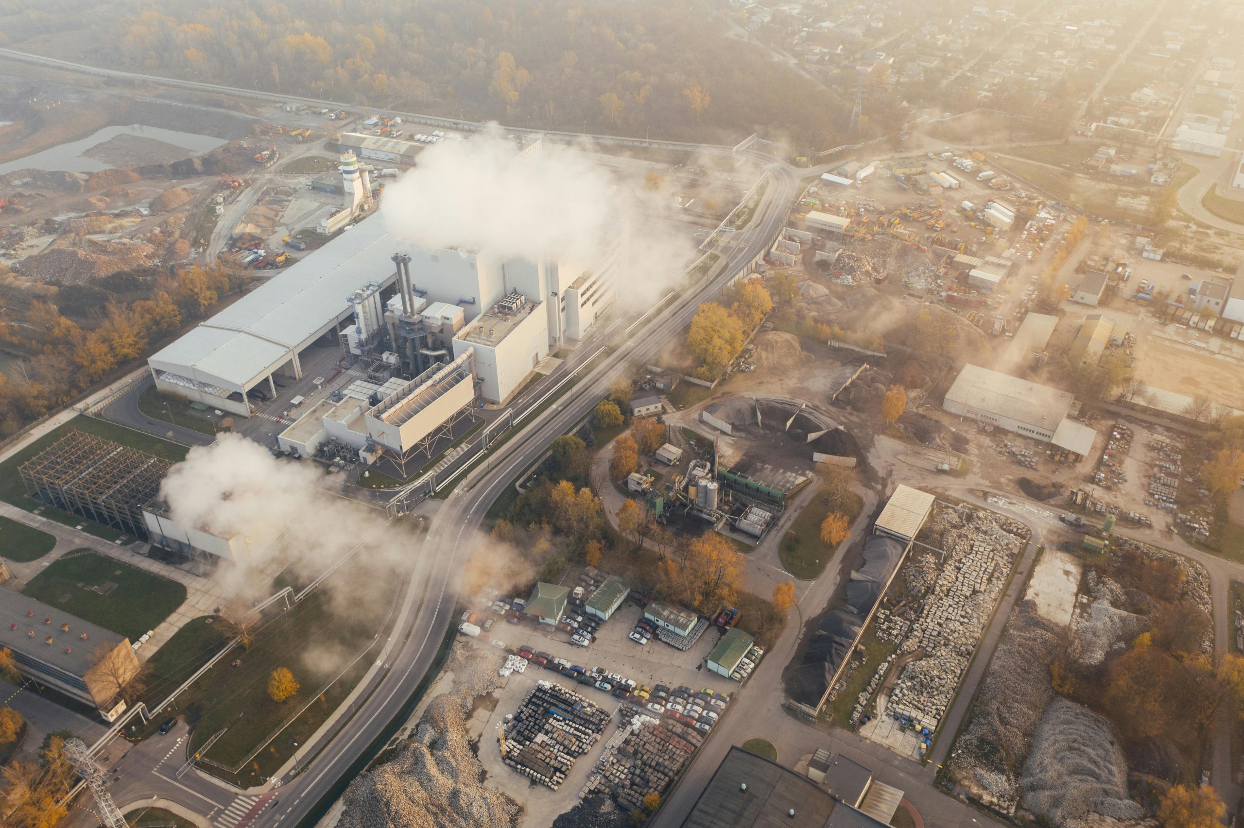 View from above of some kind of industrial plant pumping a white smoke or particulate into the air